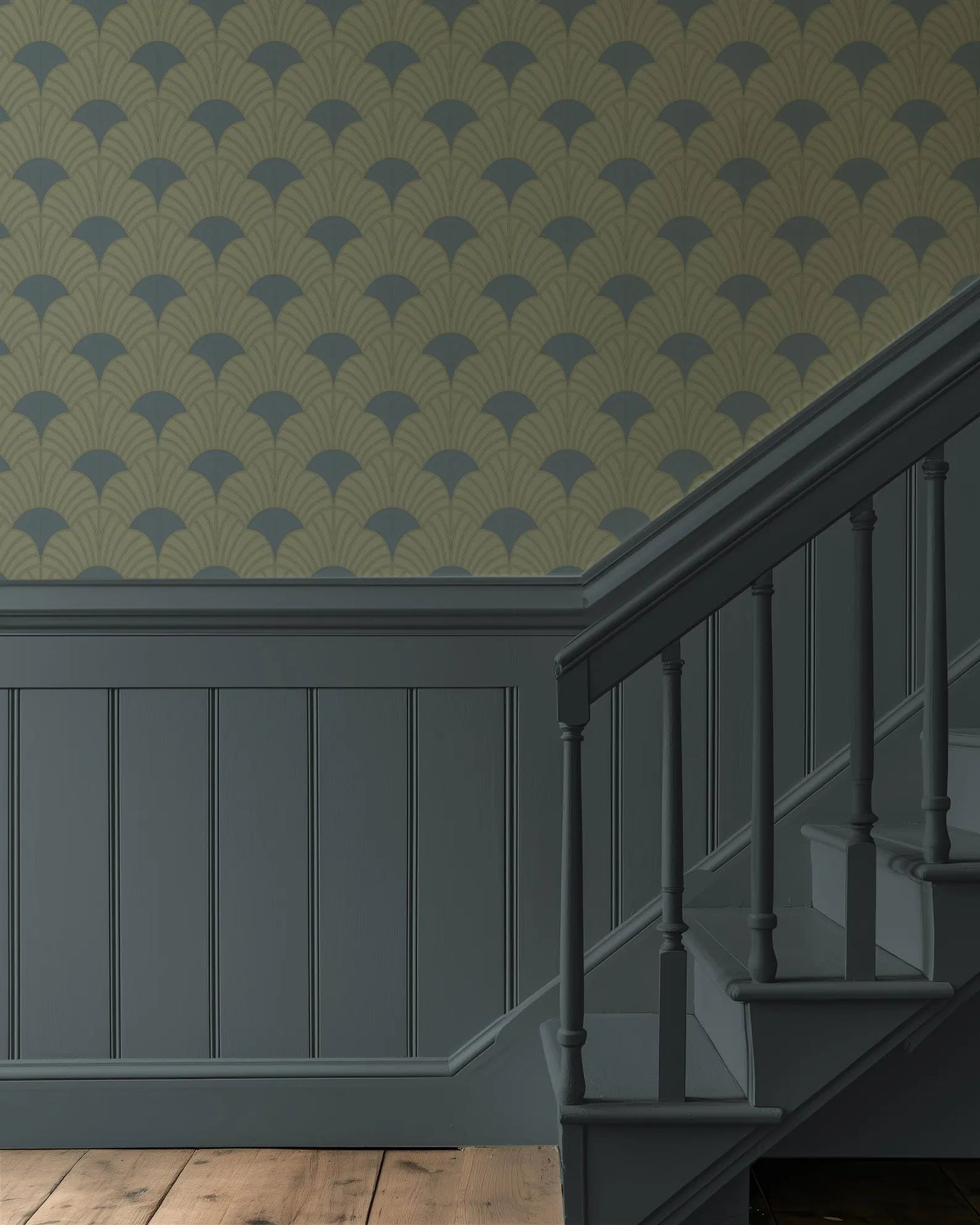 a staircase with a repeating pattern of green and gold wallpaper on the wall behind it. The staircase has a dark wooden railing and steps, creating a contrast with the lighter wall.