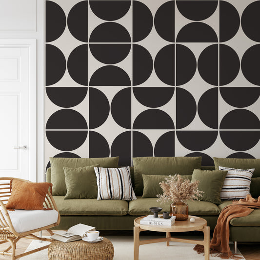 a living room with a green couch and a black and white wall