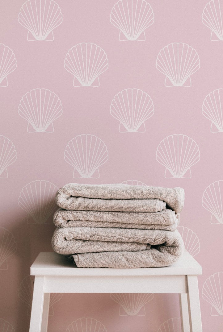 a stack of towels sitting on top of a white stool