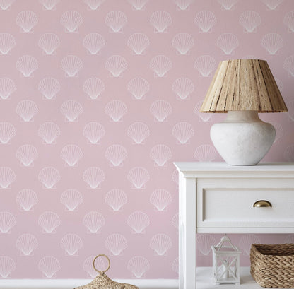 a lamp on a table next to a pink wall