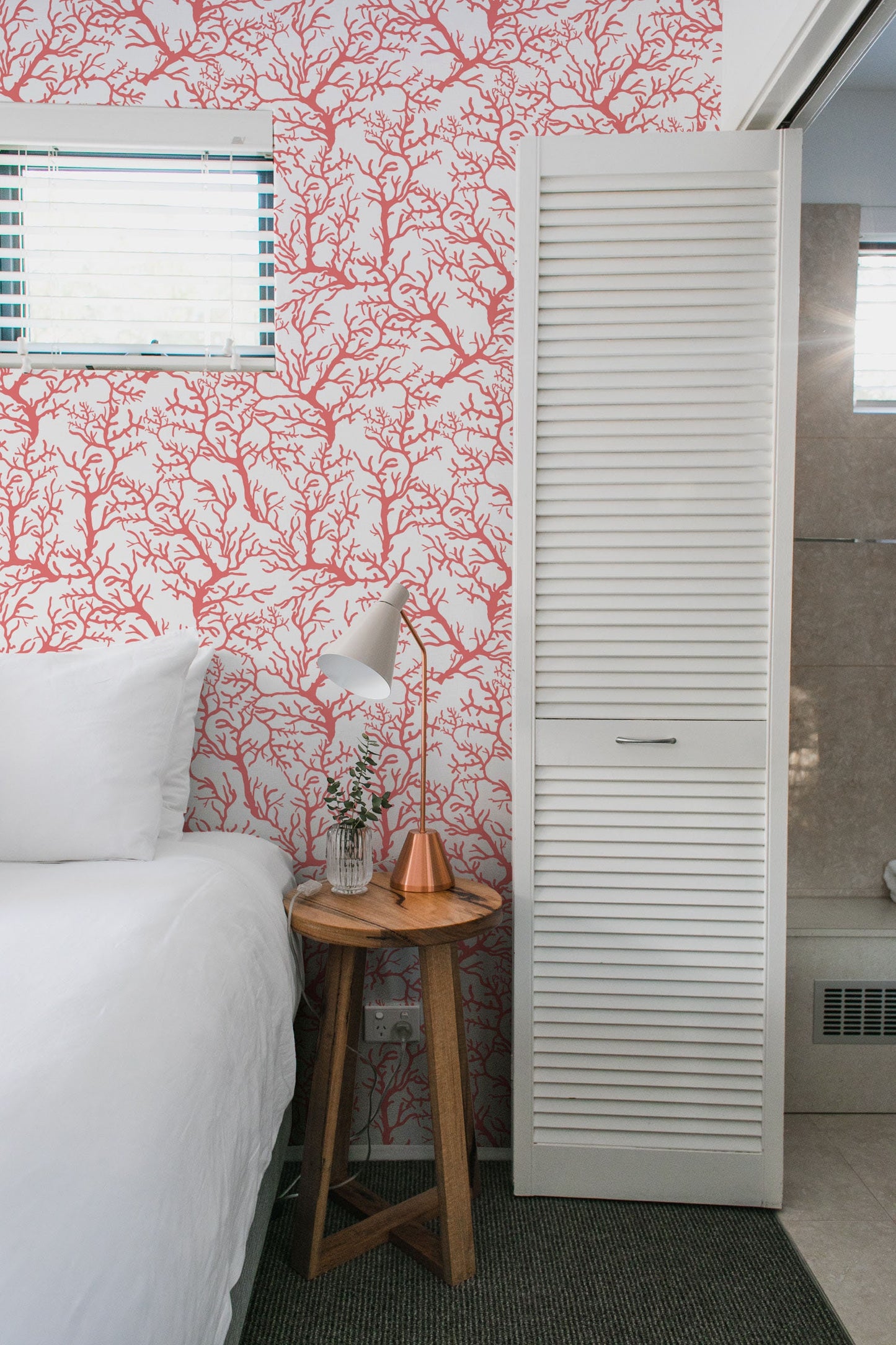 a bedroom with a white bed and red wallpaper