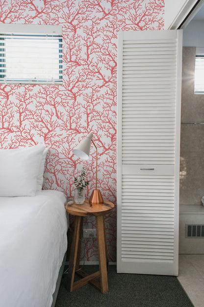 a bedroom with a white bed and red wallpaper