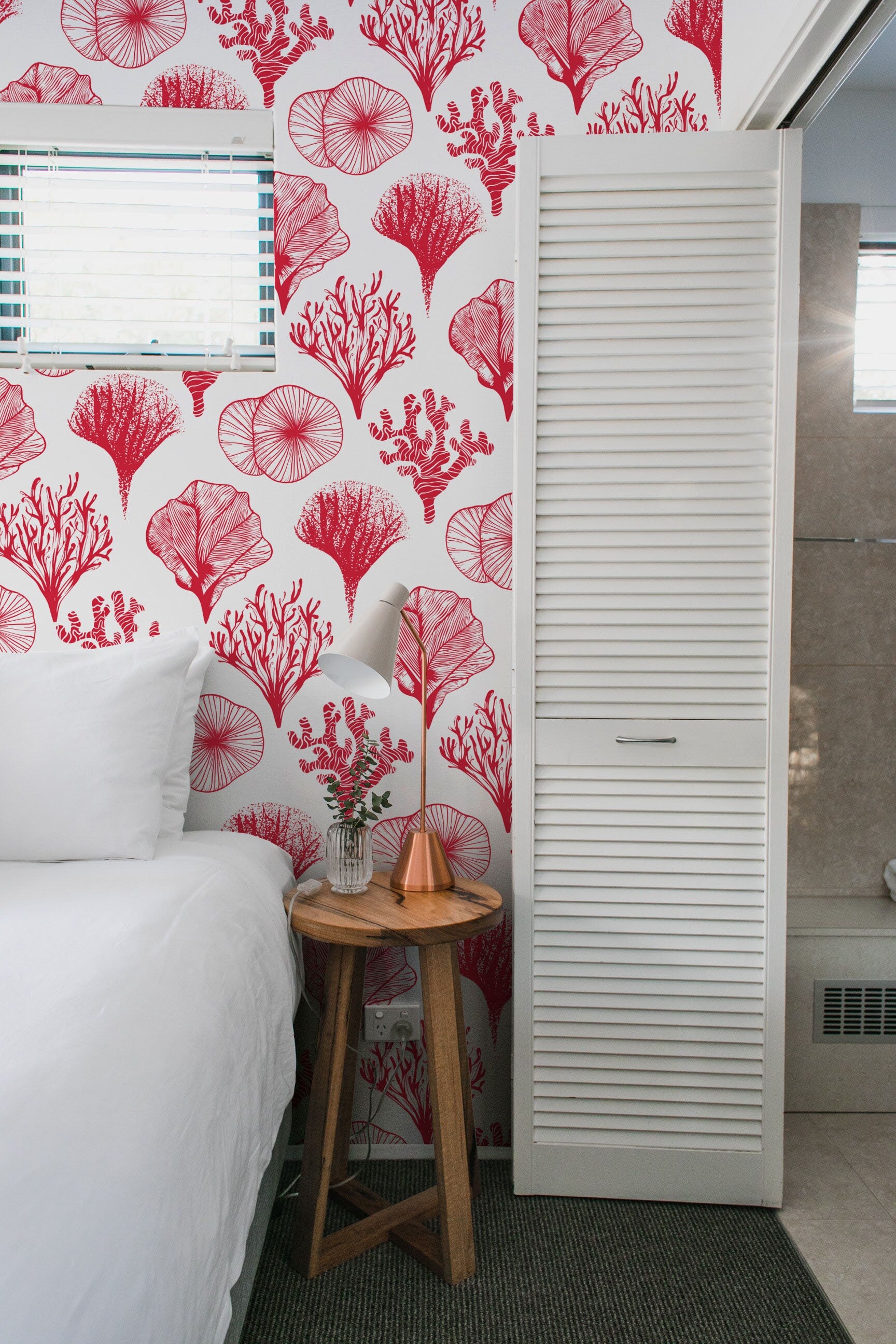 a white bed sitting next to a red and white wall