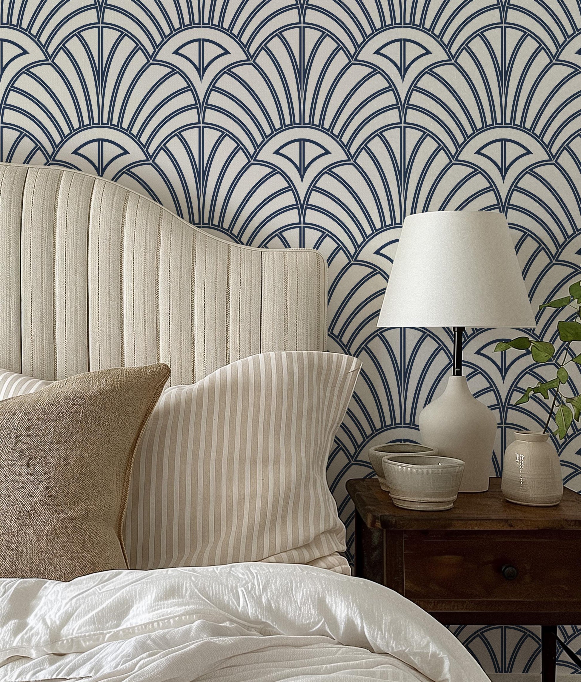 a nightstand with a lamp on top of it next to a bed