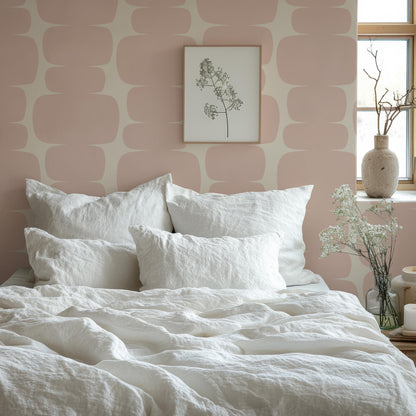 a bed with a white comforter and pillows
